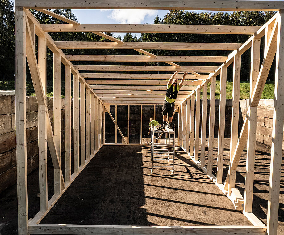 Männer arbeiten an einem Holzrahmenbau