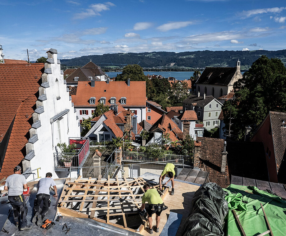 Mitarbeiter von Allgäuer Holzbau arbeiten auf einem Dach