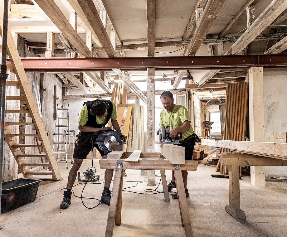 Zwei Mitarbeiter von Allgäuer Holzbau arbeiten auf einer Baustelle